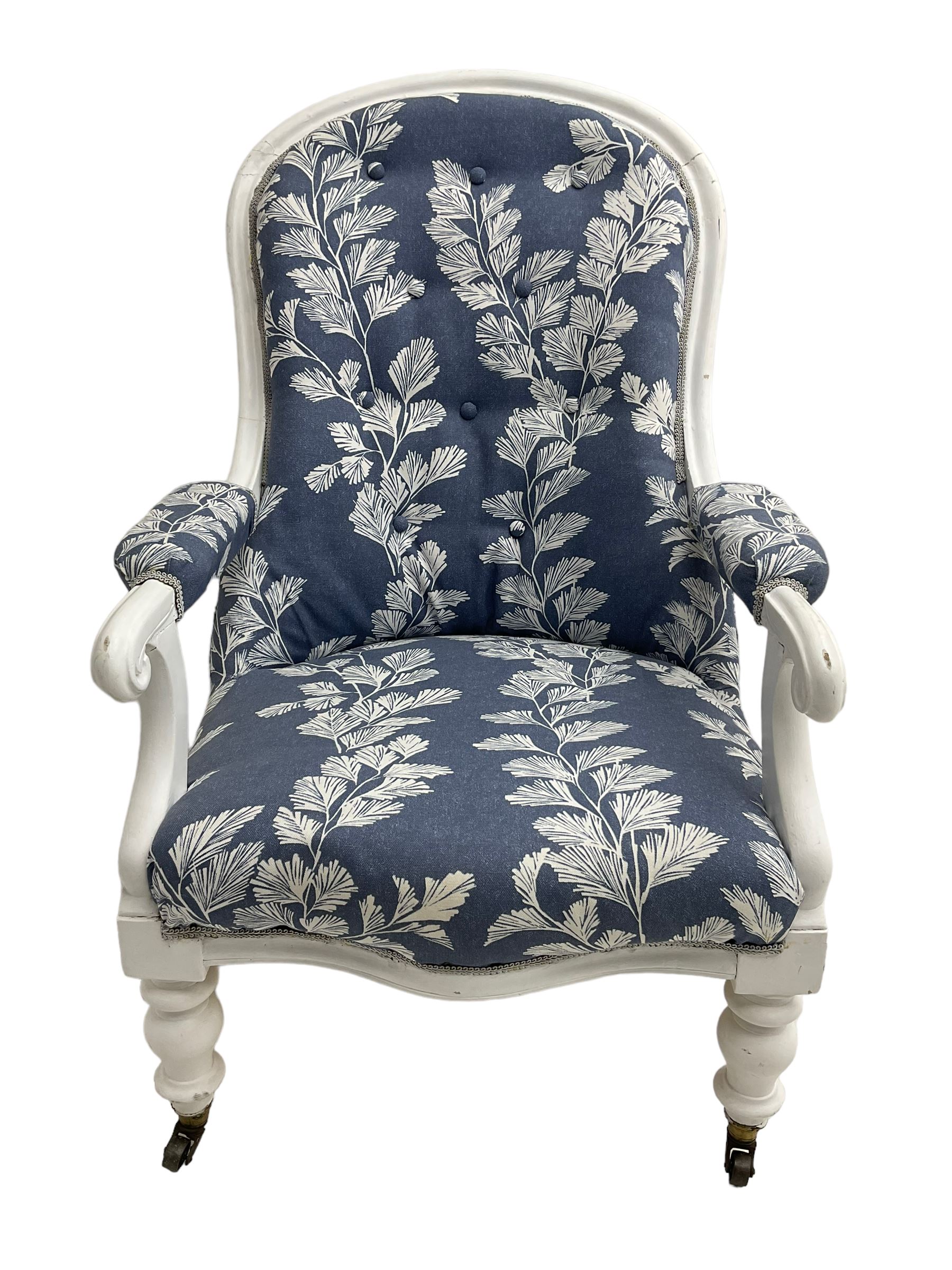 Victorian white painted open armchair, upholstered in blue fabric decorated with trailing leaf pattern, scrolled arm terminals on turned front supports with castors