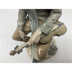 Lladro figure, Violinist, modelled as a man seated upon a  mile stone holding a violin, sculpted by Salvador Furió, no 4887,  year issued 1984, year retired 1981, H35cm