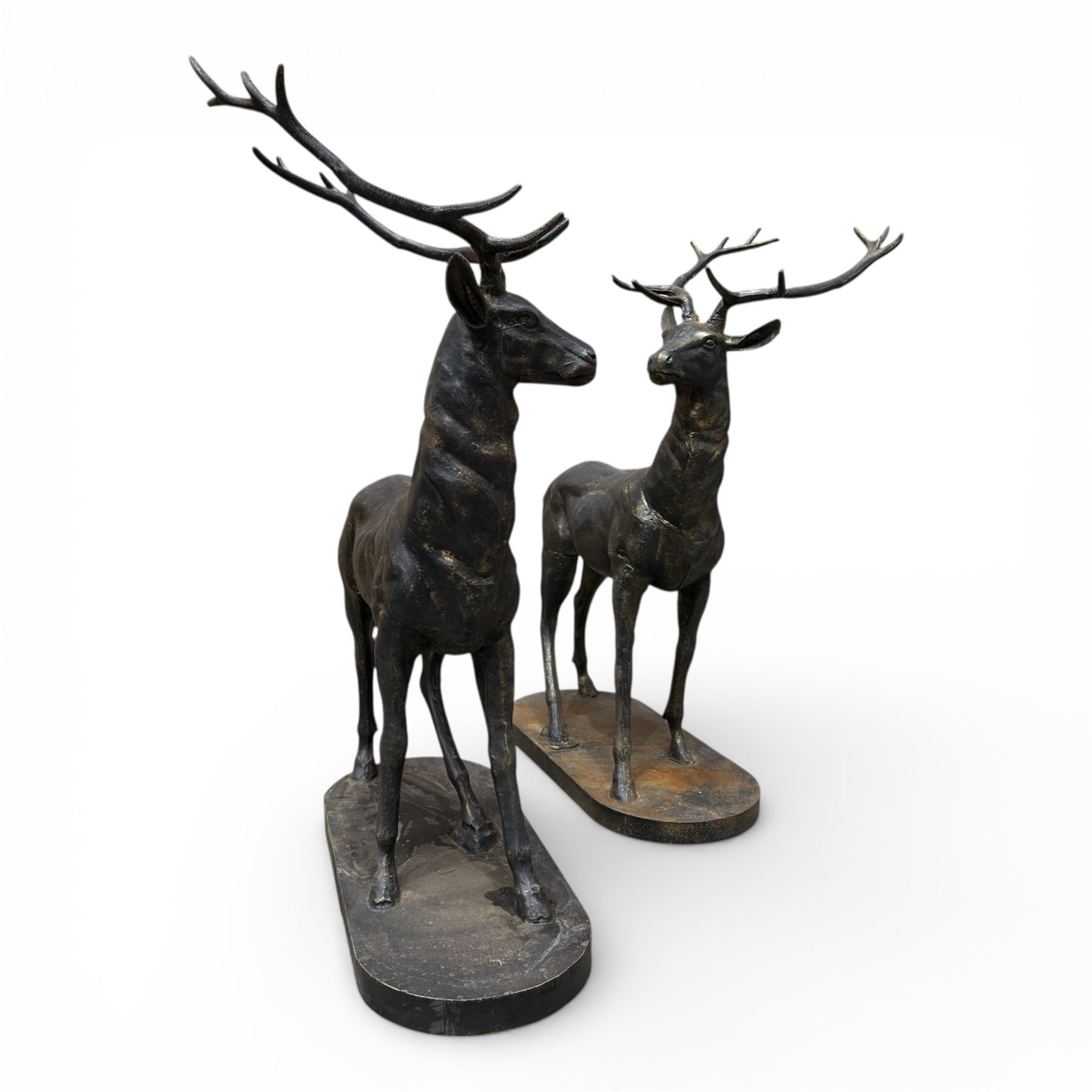 Pair of life-size cast iron garden or home stags, modelled standing upon oval plinths