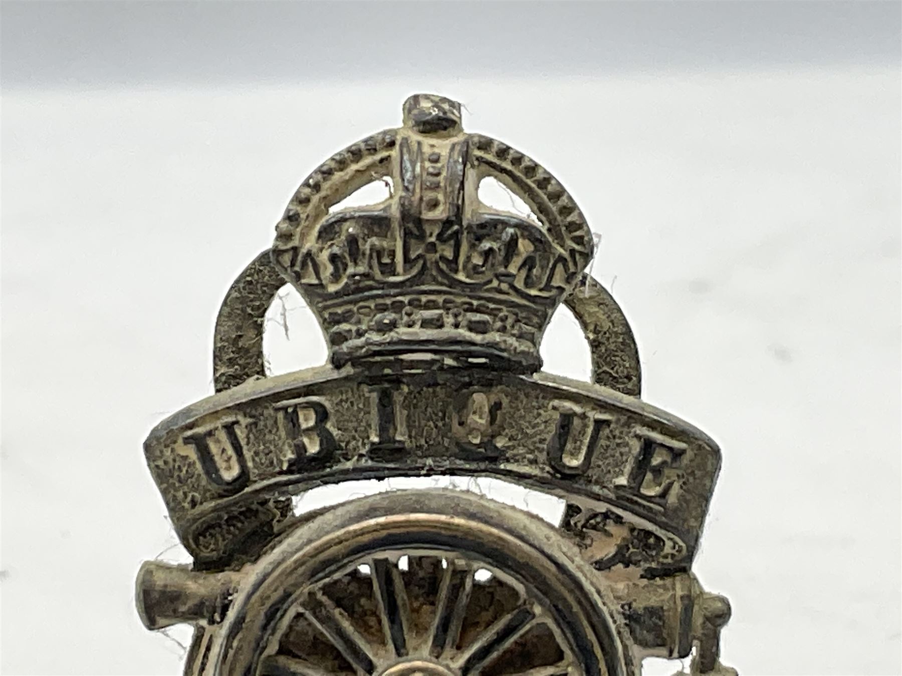 Trench Art - three WW2 brass shell case ashtrays, one mounted with Royal Artillery cap badge and button and one mounted with RA button; together with a pair of place name holders each formed from a Royal Artillery cap badge (5)