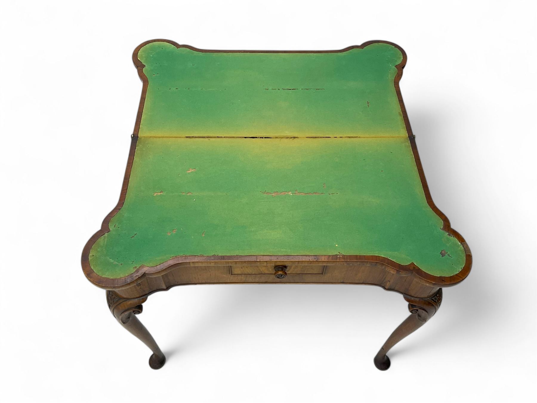 Georgian walnut fold-over card table, shaped rectangular top opening to reveal a baize-lined surface, supported by a concertina pull-out rear mechanism, frieze fitted with single drawer, raised on cabriole supports with foliate carvings terminating in pad feet