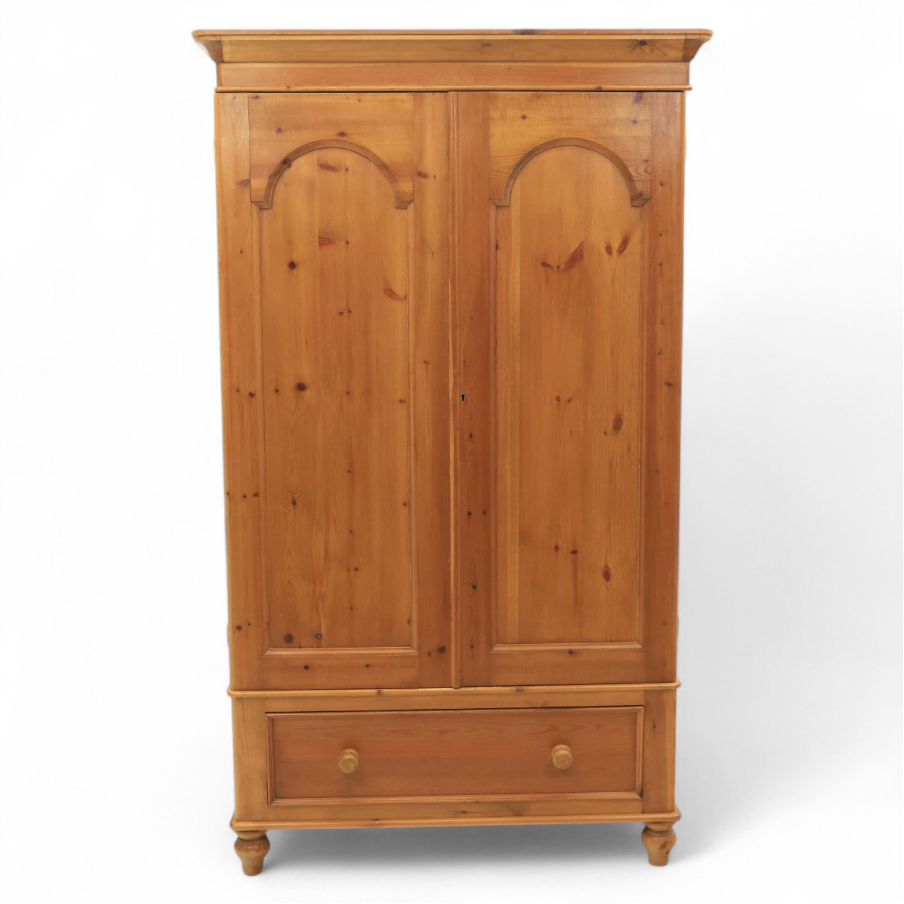 Two contemporary traditional-style wardrobes, projecting plain cornice above two arched moulded panel doors, above a full-width drawer fitted with turned wooden handles, raised on turned bun feet