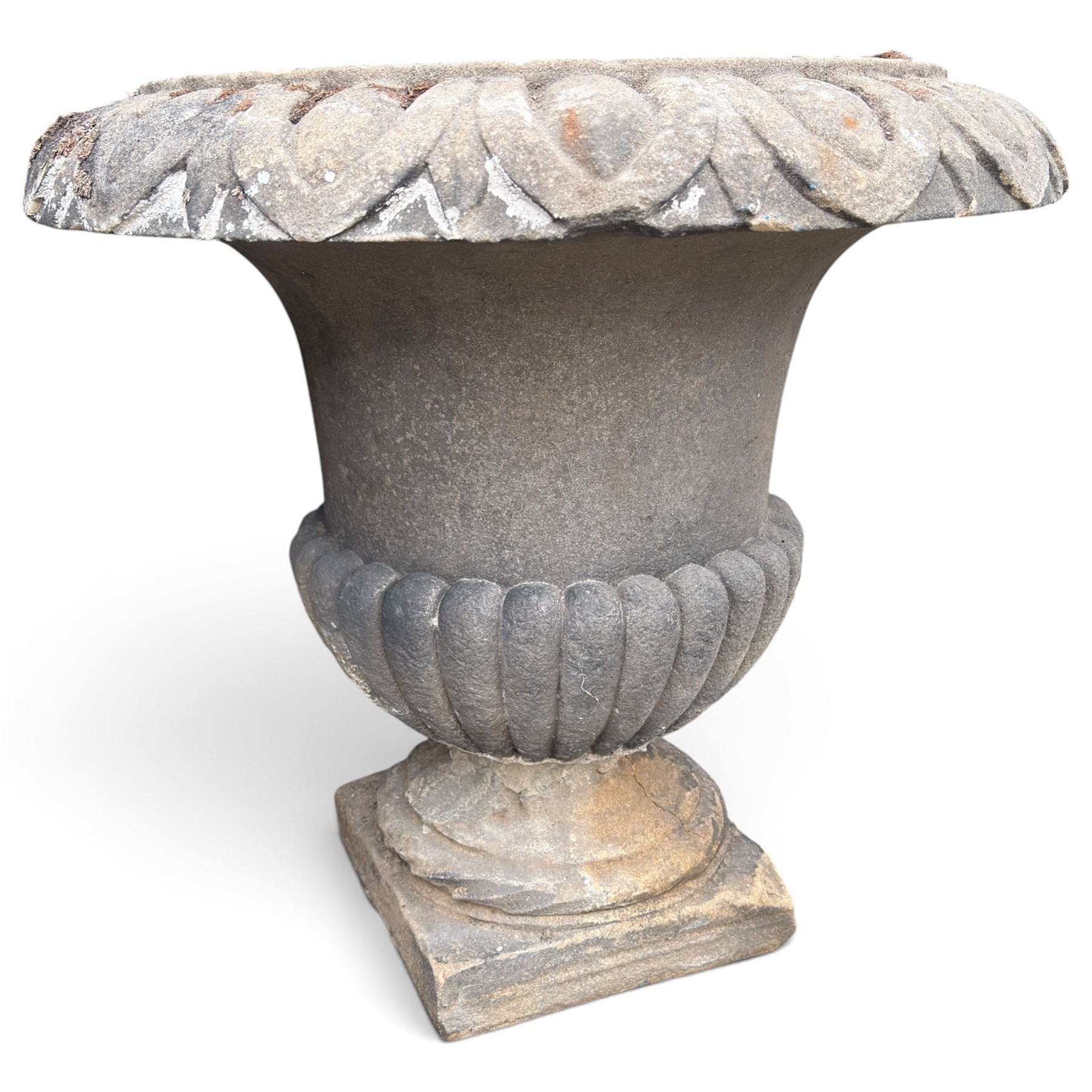 Set of three 19th century weathered carved sandstone garden urns of Neoclassical campana form, the broad everted rim carved with pointed egg-and-dart motifs, above a plain waisted bowl with gadrooned underbelly, on moulded rope-twist socle and square plinth base