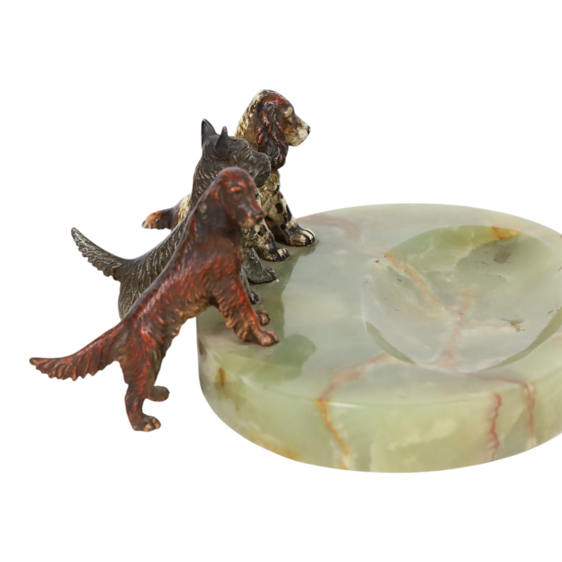 Art Deco ashtray, the oval green onyx tray with oval dished recess, the edge surmounted with three cold painted bronze dogs, comprising Irish Setter, Scottish Terrier and Springer Spaniel, each marked with incised H to base of foot, tray L17cm