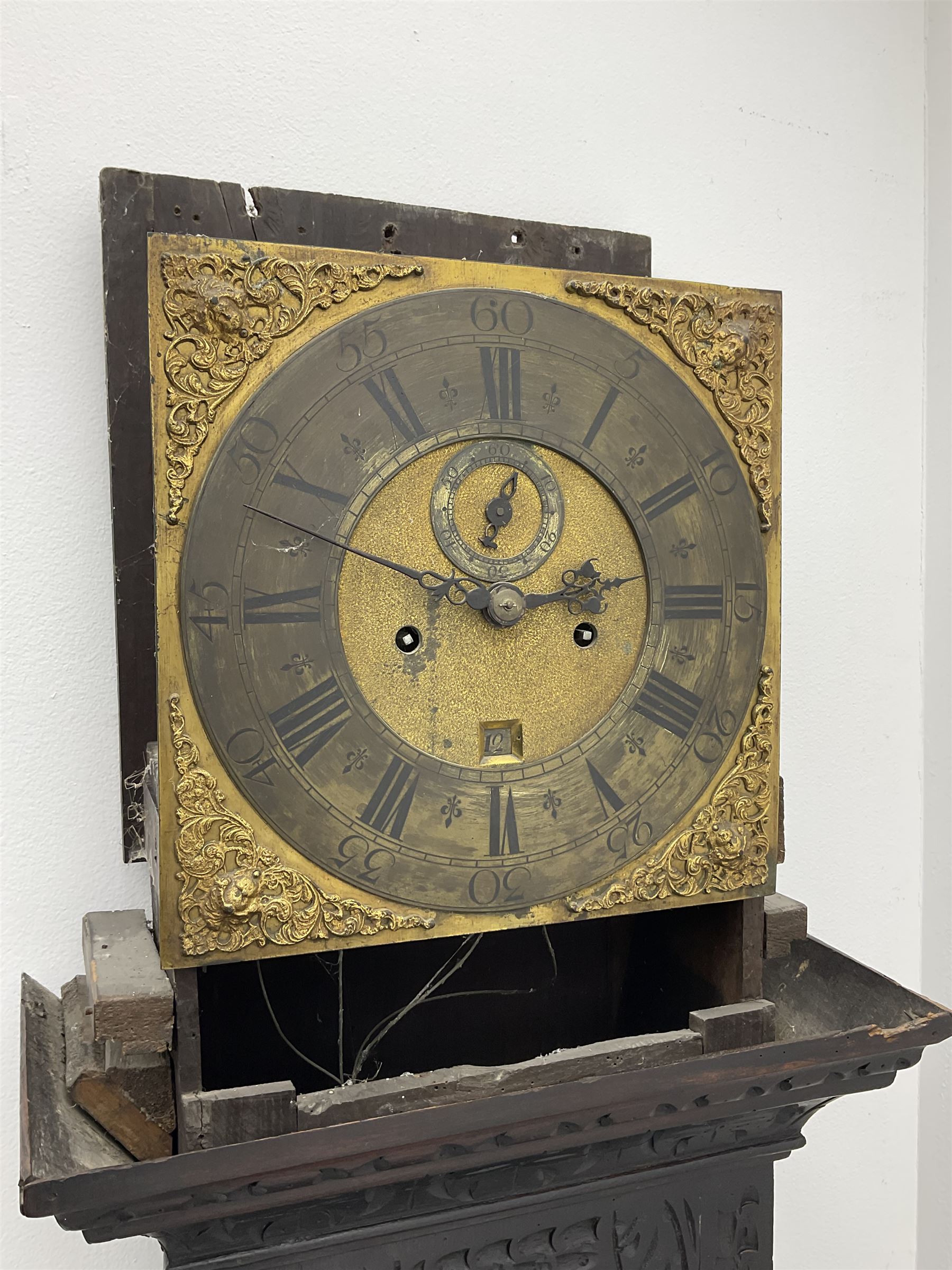 18th century oak longcase clock with later carving, the hood with projecting cornice over square glazed door, trunk door carved with tree of life, foliage carved base, on ogee bracket feet, brass dial with Roman chapter ring and subsidiary seconds and calendar aperture, ornate mask cast spandrels, twin train driven movement striking on bell 
