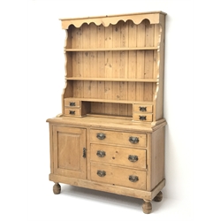  Victorian waxed pine dresser, shaped frieze above three tier plate rack with four small drawers, base fitted with single panelled cupboard and three drawers, on turned feet, W117cm, H187cm, D43cm  