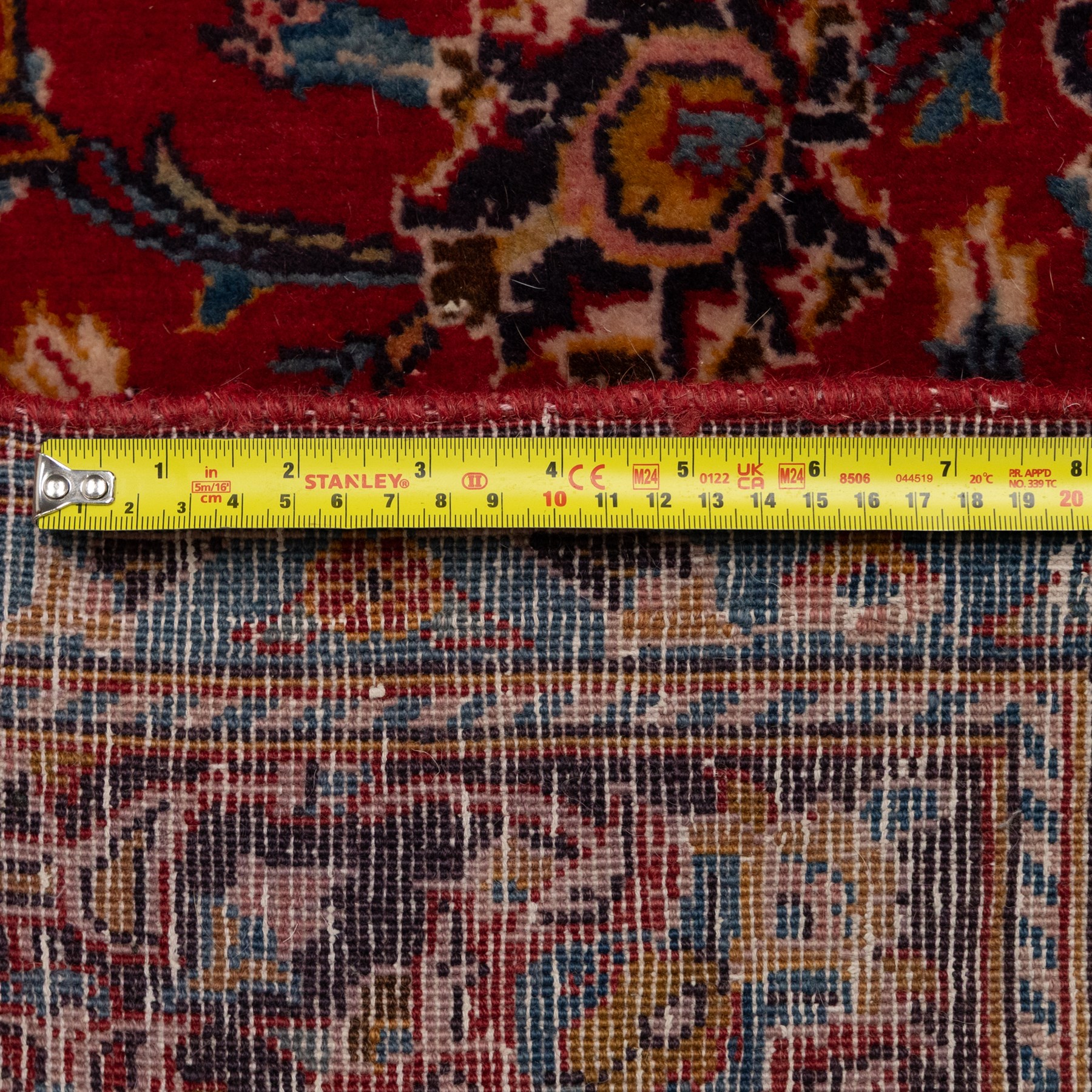 Two Persian rugs, the larger with a crimson field decorated with three linked indigo medallions amongst flowering tendrils, shaped floral spandrels and an indigo palmette border, (161cm x 129cm), the smaller with a crimson field centred by an ivory rosette amongst stylised flowering plants, within a dark floral border, (114cm x 79cm) (2)