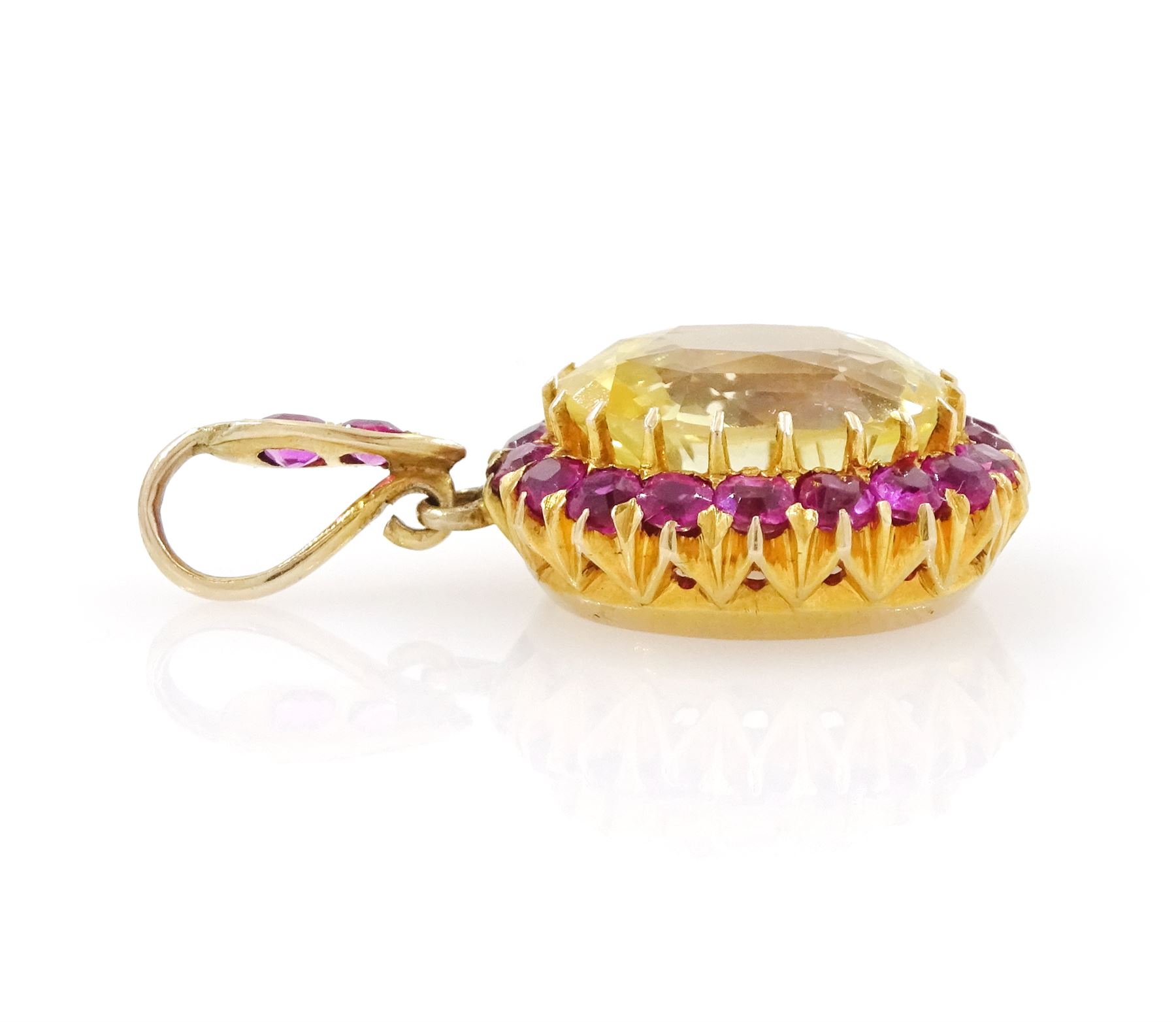 Gold yellow sapphire and ruby pendant, single cushion cut sapphire of approx 10.20 carat, surrounded by nineteen round cut rubies and ruby set bail