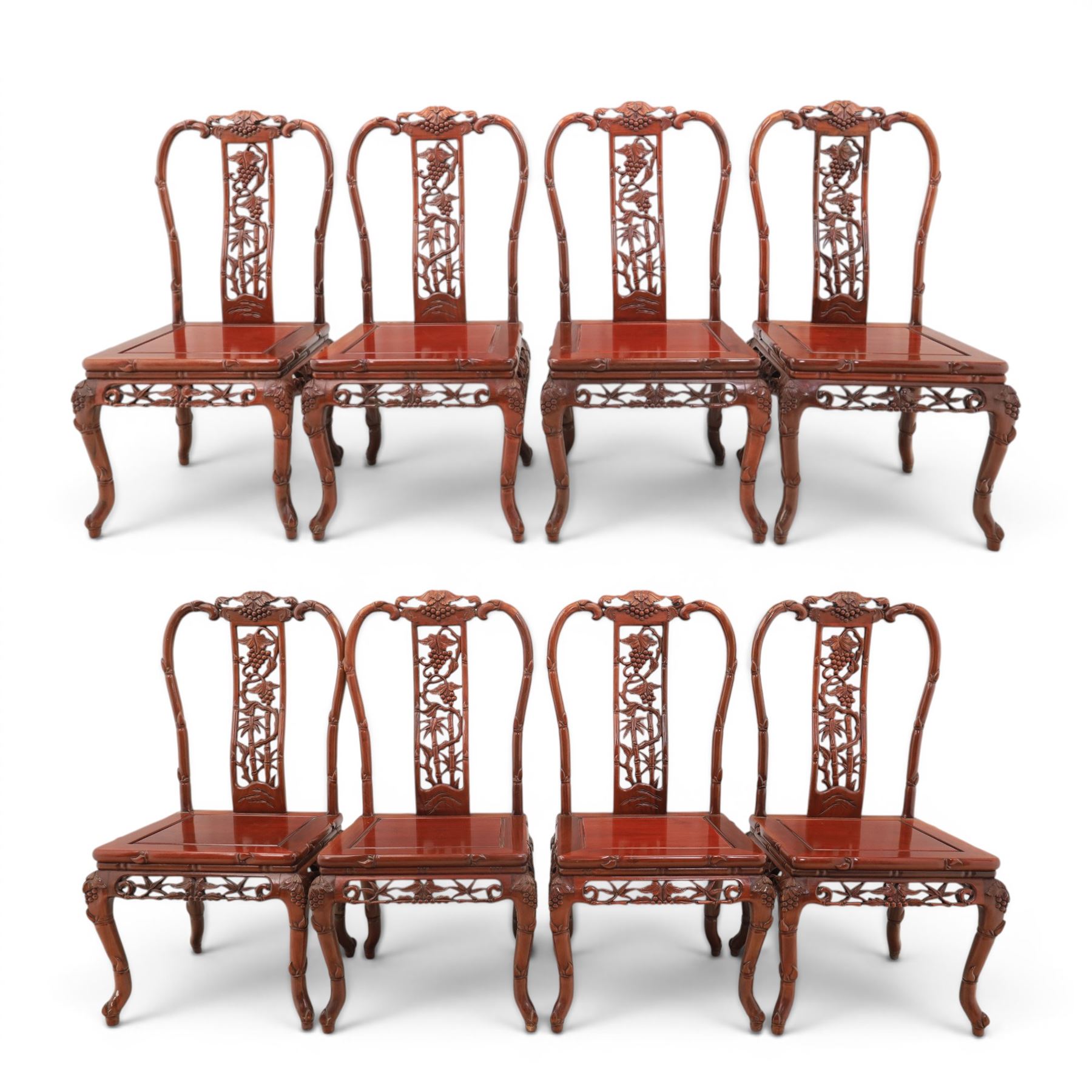 20th century Chinese ornately hardwood dining table and chairs, circular table with 'Lazy Susan' top with pierced carved frieze, raised on a quadriform base with carved foliate detail, the chairs en suite with carved pierced detailing  