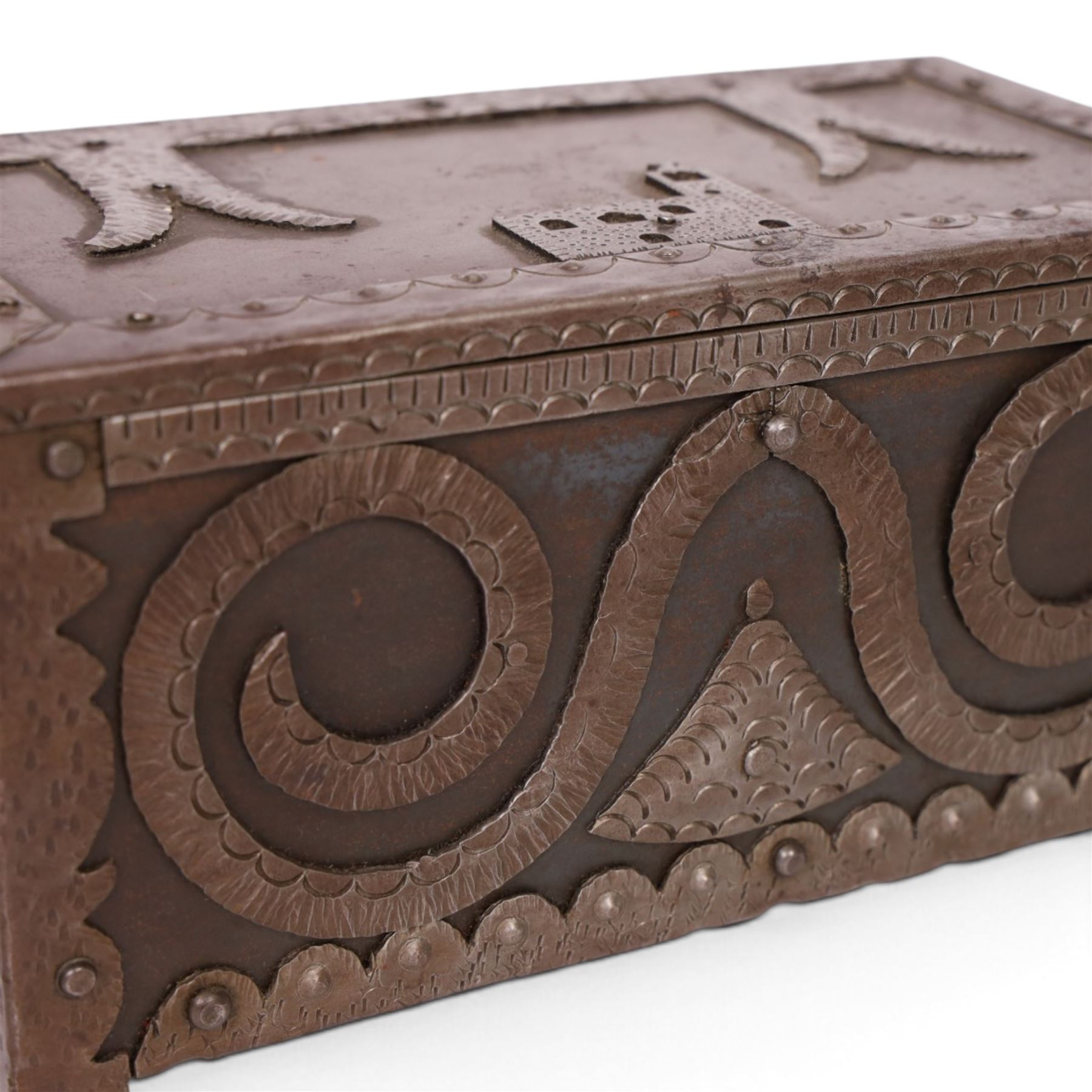 Late 19th/early 20th century vernacular iron box, the hinged cover and sides with applied strapwork decoration, the cover with applied church motif, H11.5cm W22cm D12cm