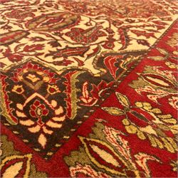 Persian Kerman hand-knotted rug, ivory and crimson ground, central medallion surrounded  by a floral foliate pattern, main border with repeating design of floral cartouches and palmettes, and narrow vine work guard border  