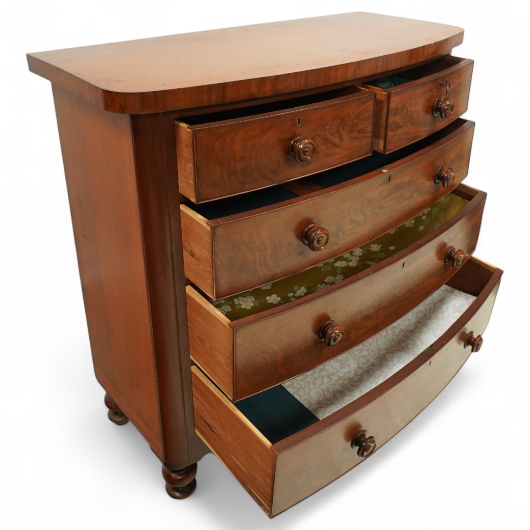 19th century mahogany bow front chest, with figured drawer fronts comprising two short over three long drawers, all with turned handles, shaped lower frieze and raised on turned supports