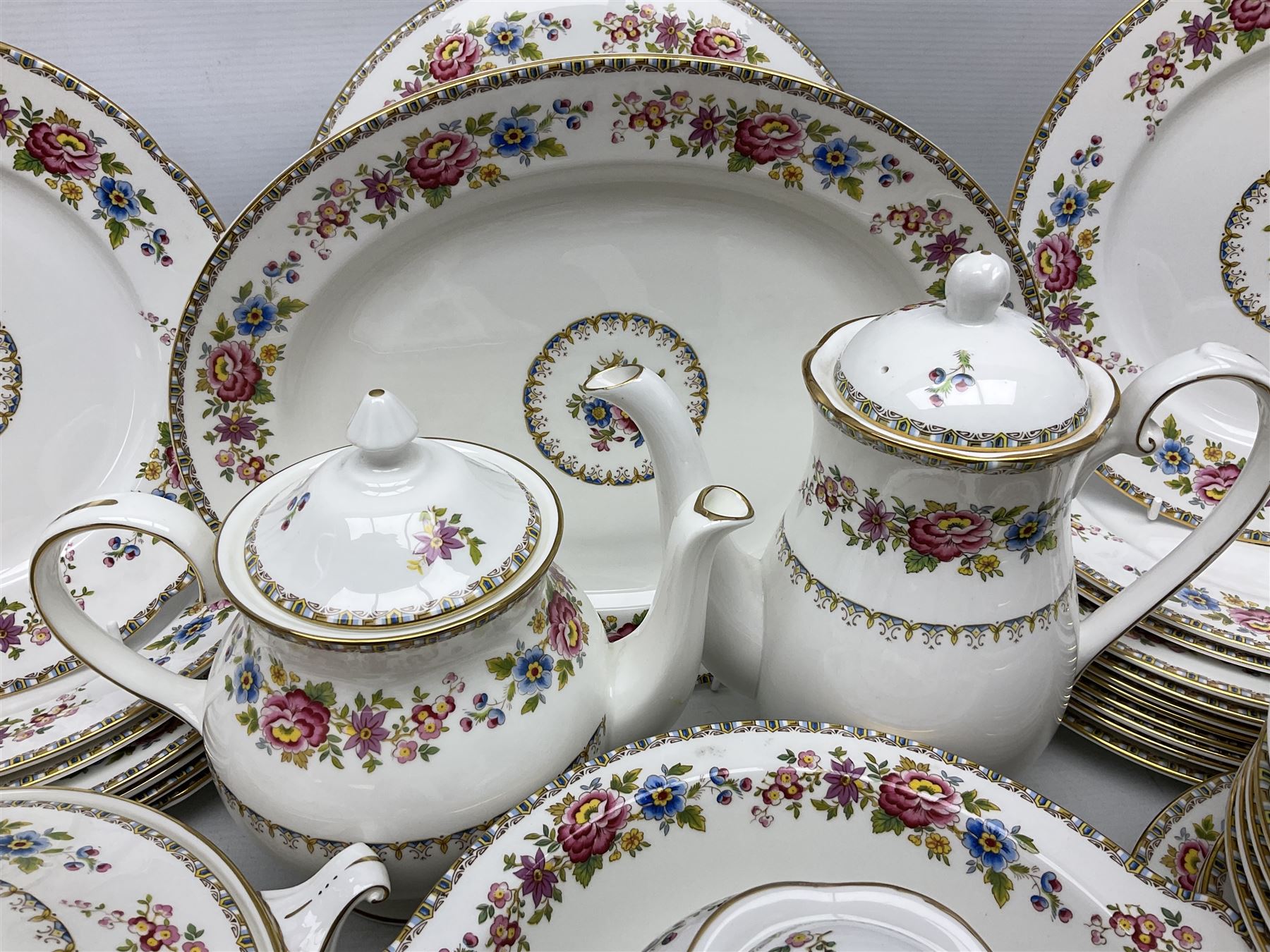 Extensive Royal Grafton Malvern pattern tea and dinner wares, comprising twelve dinner plates, six smaller plates, coffee pot, two teapots, two cake plates, eight teacups and ten saucers, six coffee cups and six saucers, two open sucriers, twin handled lidded sucrier, jug, lidded mustard pot and condiment jar, lidded tureen, two circular twin handled vegetable tureens, sauce boat and stand, oval and circular serving plates, salt and pepper shakers, breakfast cup and two saucers, further large cup and saucer, eighteen tea plates of various shapes, six side plates, six cereal bowls and six further bowls, shell dish and dish of square form, fork and knife, together with a hallmarked silver condiment spoon