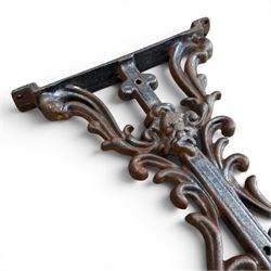 Pair of Victorian cast iron table end supports, of pierced and scrolling foliate design with central masks, united by X-form stretcher, with later top