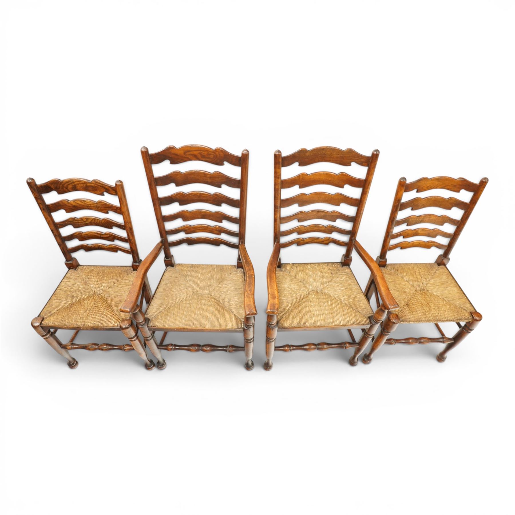 Set of eight country ladderback chairs (6+2), shaped ladderback over a rush seat, raised on turned supports, united by stretchers