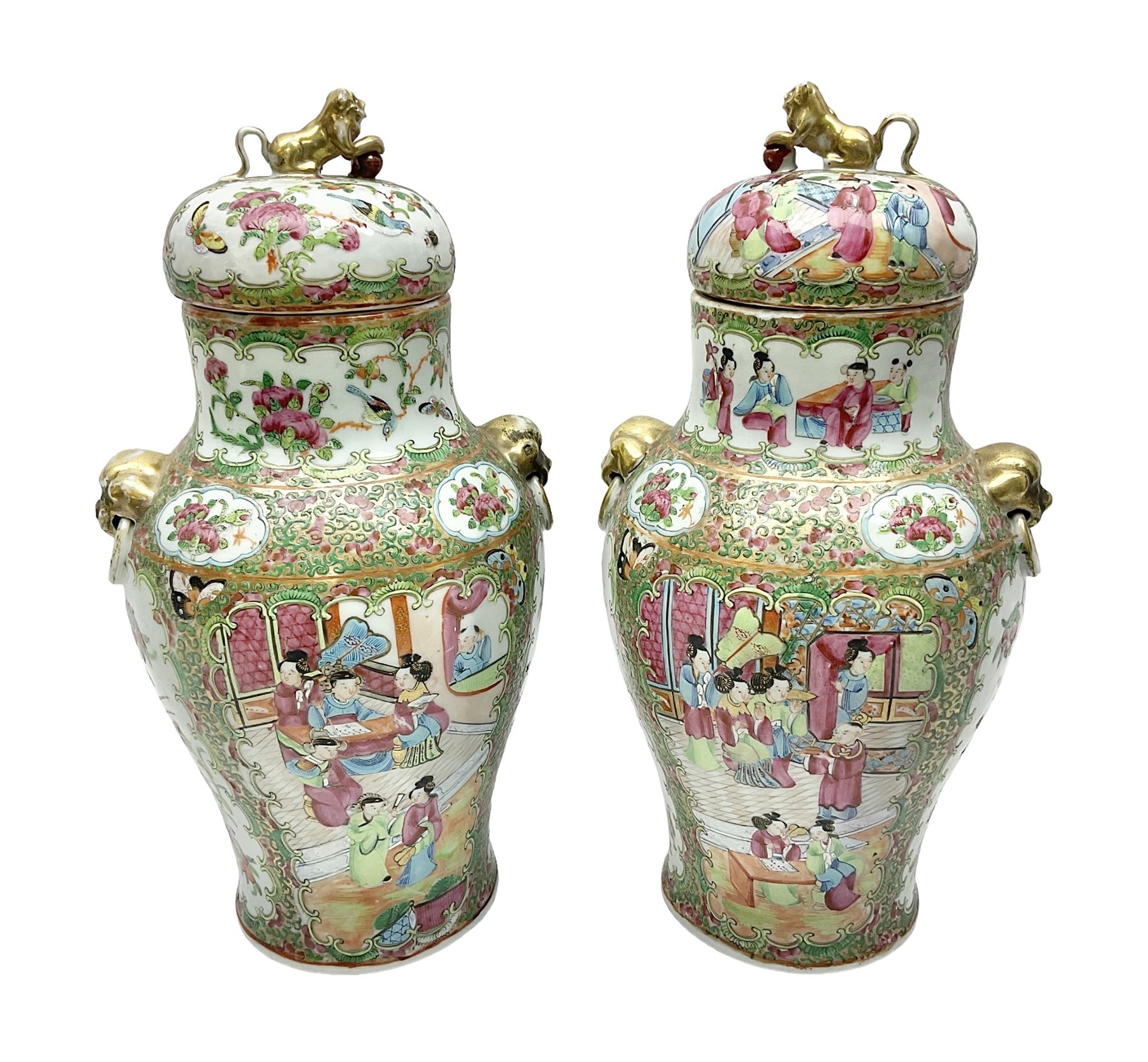 Pair of 19th century Chinese Famille Rose vases and covers, each of baluster form with twin gilt lion mask ring handles to shoulders, the flattened domed covers with gilt temple lion finials, each decorated with alternating reserves of bijin and attendants, and birds and butterflies amongst blossoming peonies, against a gilt ground profusely decorated with stylised scrolls, H32.5cm