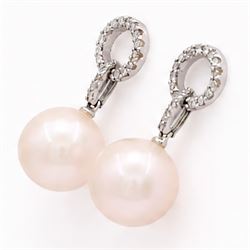 Pair of 18ct white gold pearl and diamond pedant earrings, each stud set with a halo of round cut diamonds, suspending further diamonds and a single peach / pink pearl, stamped 750