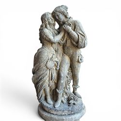 Composite garden statue group of Romeo and Juliet embracing, the couple adorned in Medieval dress standing on a naturalistic base with fallen flowers, raised on a Neoclassical fluted pedestal with Anthemion leaf motifs