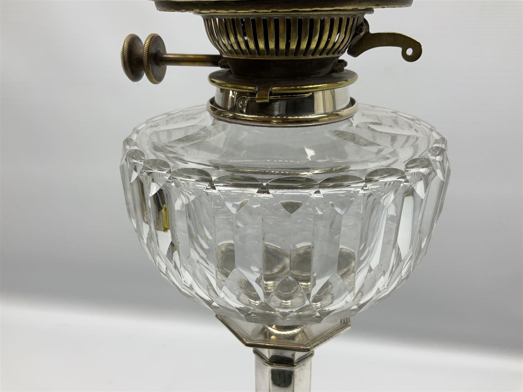 20th century Hawksworth, Eyre & Co silver plated oil lamp, the octagonal stepped base with engraved dedication, leading to an octagonal column supporting a faceted clear glass reservoir, Hinks Duplex burner, clear glass chimney, and cranberry glass shade, overall H71.5cm