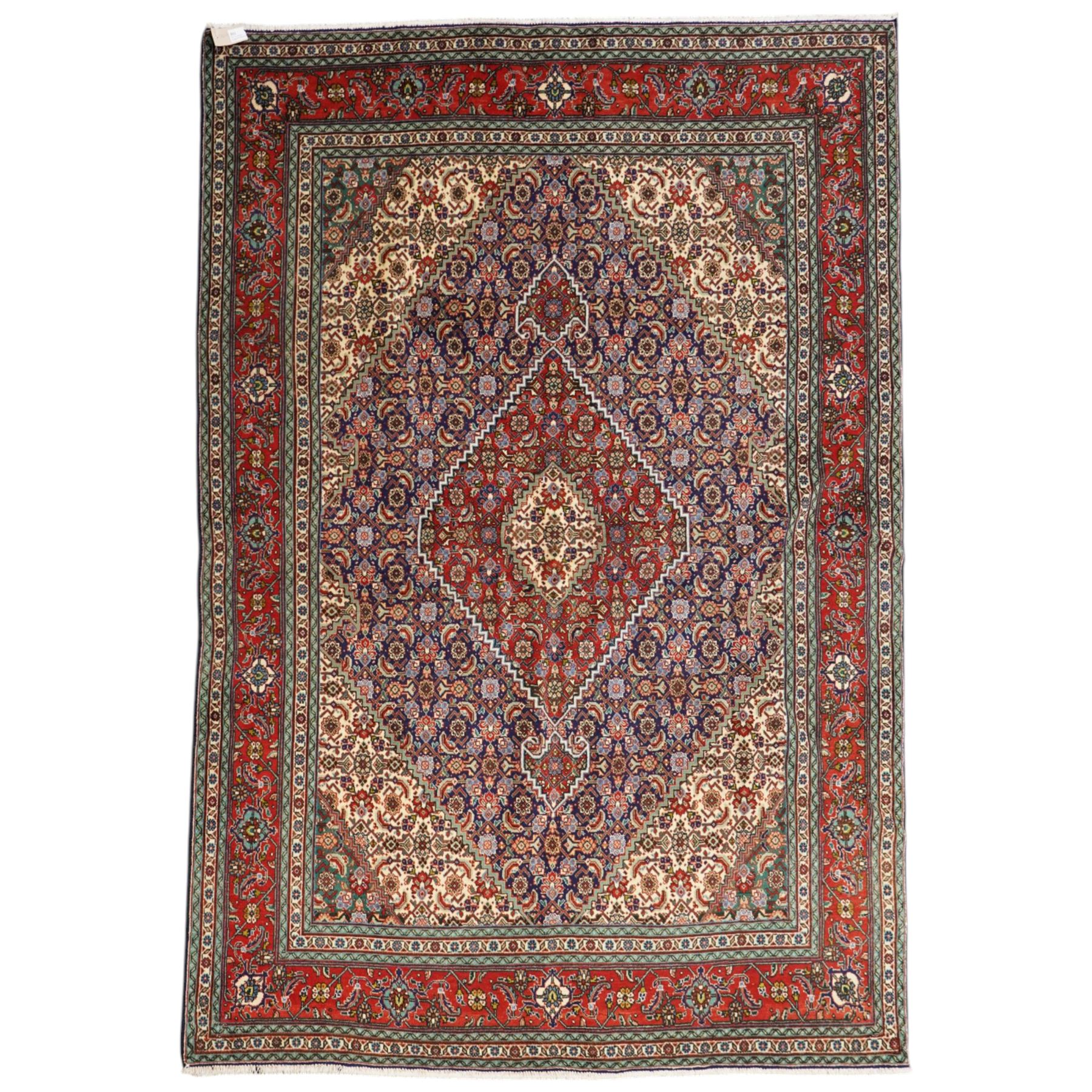 North West Persian Tabriz hand-knotted rug, ivory field with a central lozenge medallion in deep indigo and madder red, enclosing a inner reserve with stylized floral motifs, spandrels with angular floral sprays, main border of repeating floral vinery and palmettes, framed by multiple guard borders, with cotton fringe ends