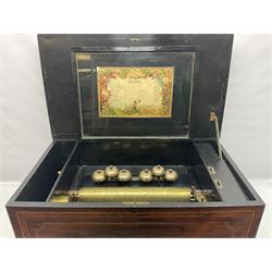 Large 19th century Swiss cross-banded rosewood and ebonised bells-in-sight musical box; the hinged lid with floral marquetry panel opening to reveal an ebonised interior with hinged glazed door covering a 33.5cm brass cylinder playing twelve airs on a 32.5cm single piece comb with sixty-two teeth and six tiered graduated engraved saucer bells with strike/silent facility; brass cranking handle with change/repeat and stop/play selectors; manuscript song sheet under lid detailing twelve airs and dated 1865; ebonised block feet L65cm