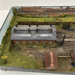 '00' gauge - table top model railway layout with multiple tracks around a central engine shed with other buildings and figures, diorama on three raised sides and open tunnel to one end for further extension, wired for electricity, main layout 104 x 52cm