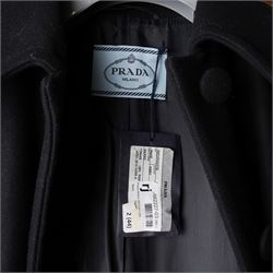 Prada - black Melton wool coat, in a redingote style with front fastening and fabric-covered buttons, flap pockets and a structured collar with slit to the back, size 44, unused with the original garment bag and hanger