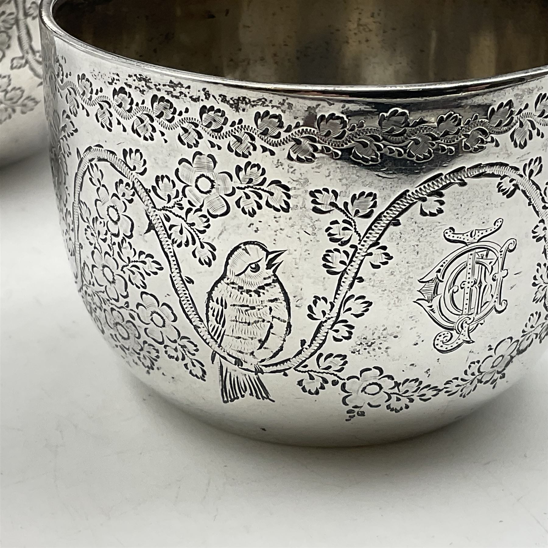 Late Victorian silver bachelors three piece tea service, comprising bullet shaped teapot, open sucrier and milk jug, each engraved with monogram surrounded by birds upon and amidst a blossoming vine, the teapot with scroll capped curved wooden handle and wooden finial to cover, hallmarked Wakely & Wheeler, London 1890, teapot including handle H12cm, sucrier H5.5cm 