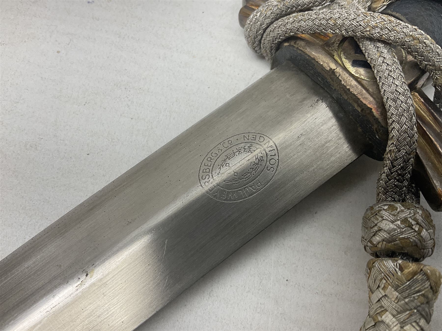 German Paul Weyersberg & Co Solingen DLV flyers dagger with 18cm steel blade, plated brass/tombac downswept cross-piece and pommel and leather covered grip, in leather and plated brass/tombac scabbard with leather hanger strap and silvered knot L35cm overall. Auctioneer's Note: After WWI Germany was forbidden an air force by the Treaty of Versailles however the Deutscher Luftsport-Verband (German Air-sport Association) was formed in March 1933 from various sports flying clubs and had branches for aeroplane, gliding and balloon flying. Under cover of the sporting DLV, many future Luftwaffe pilots trained to fly. DLV was embodied with the NSKK in March 1935 and on 1st March 1937 Luftwaffe was formed.