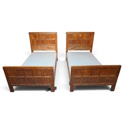 Mouseman - pair of 1930's adzed and panelled oak single beds, the head and foot-boards wit...