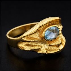 18ct gold Swiss blue topaz ring, bezel single oval cut topaz, within an abstract creased design setting, stamped 750