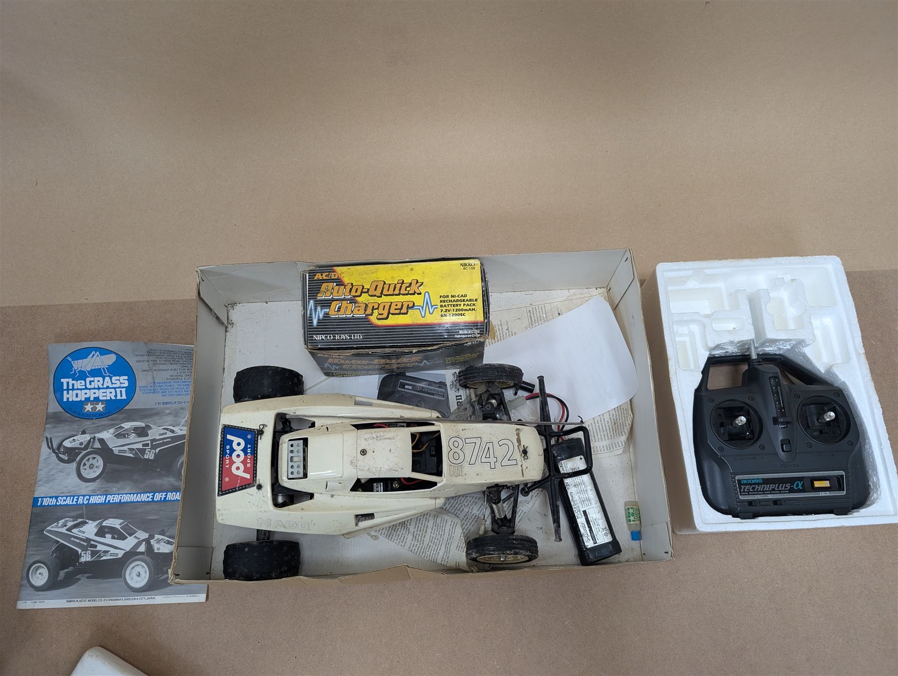 Tamiya 'The Grasshopper' 1:10 scale remote control car, boxed, together with an Acombs Techniplus-a controller, both boxed