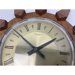 Mid-century teak sunburst wall clock by Anstey & Wilson, modelled with angular teak rays spreading from circular mount with plain brass face with Roman numerals, with battery operated Japanese movement, D45cm