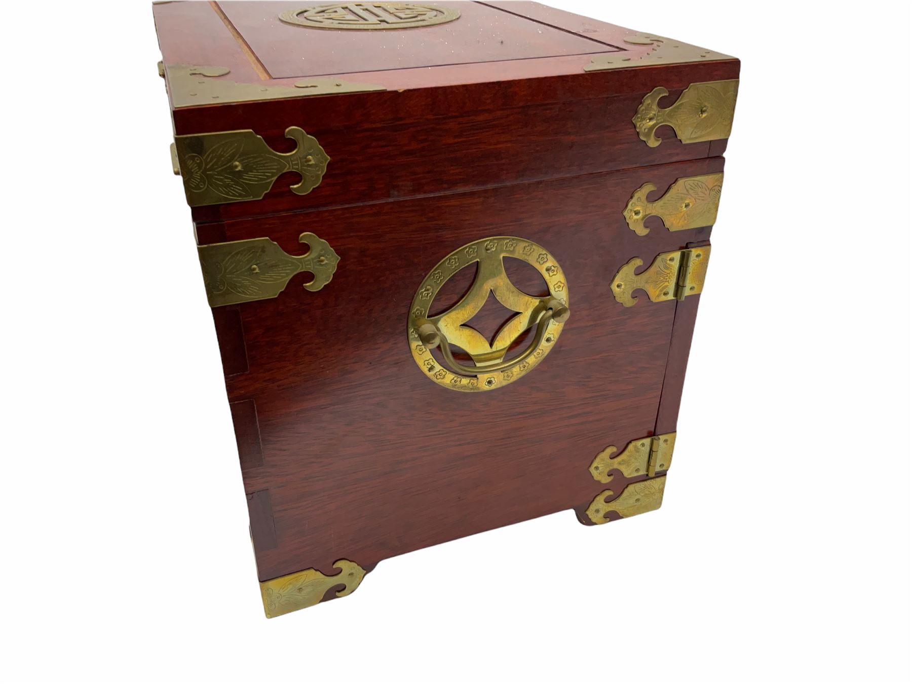 Chinese hardwood jewellery box mounted with engraved brass fixtures, the two exterior doors revealing three drawers below the hinged upper lid, lined with red material decorated with floral sprays, H25cm, W36cm, D23cm