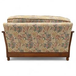 Ercol – bergère four piece suite, including armchair, two seat sofa, three seat sofa and footstool, all with removable floral upholstered cushions, the frames with side caning and rounded arm supports in stained beech

Three seat (H 87cm, D 89cm, W 196cm)
Two seat (H 87cm, D 89cm, W 137cm)
Armchair (H 87cm, D 89cm, W 87cm)
Footstool (H 28cm, D 55cm, W 55cm)