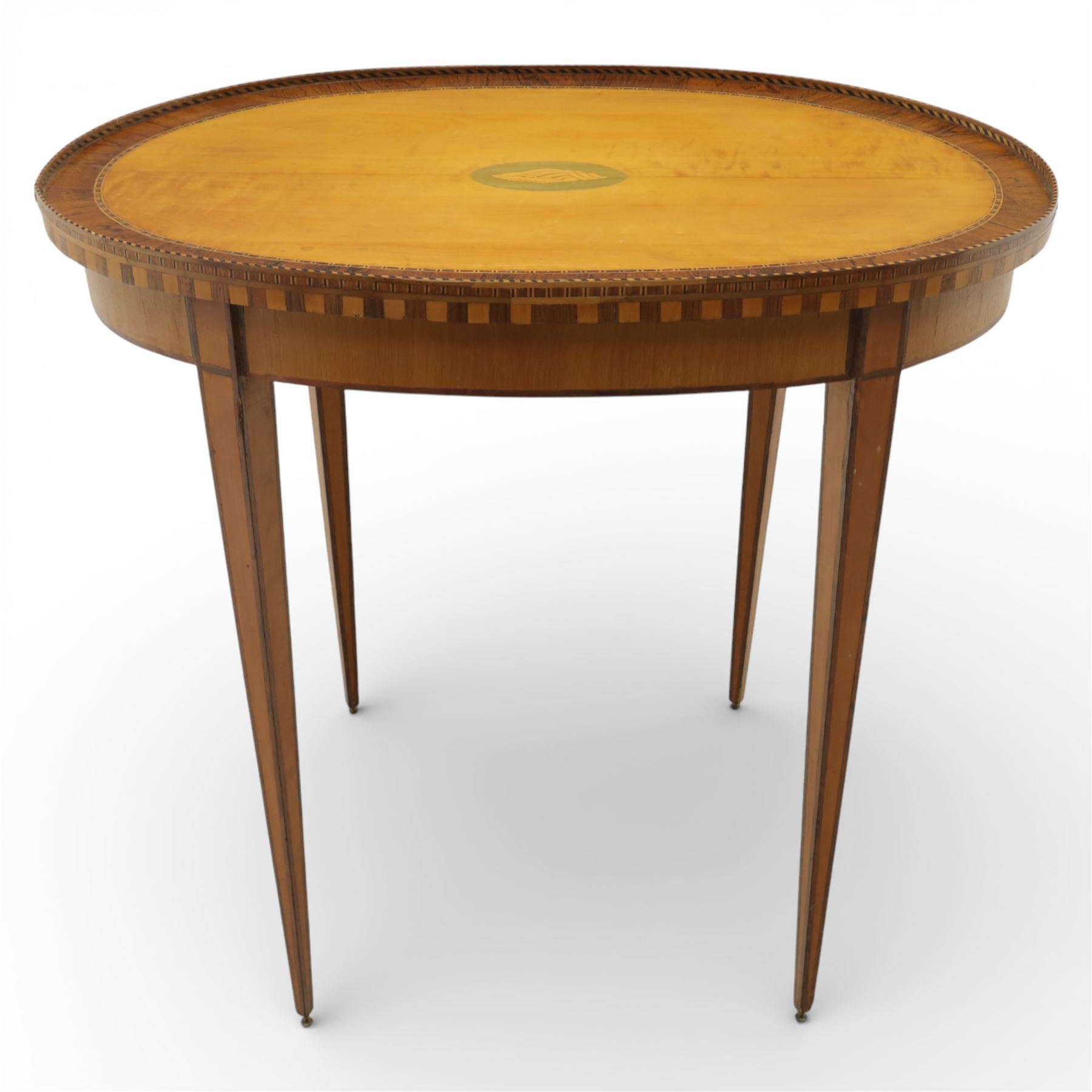 Early 19th century Sheraton revival satinwood oval table, shell motif to the centre bordered by walnut veneer, with inlaid banding, supported on square tapering legs terminating in brass feet
