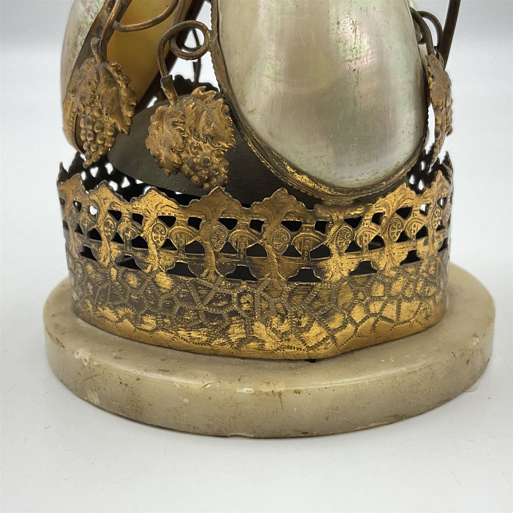 Victorian evening dinner bell, with three mother of pearl shells, floral and grape gilt decoration, and bird finial, raised upon a circular soapstone base with gilt pierced gallery, H14cm