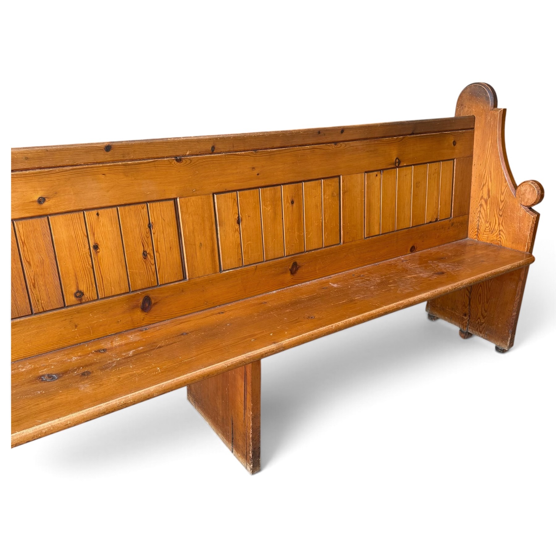Early 20th century stained pine ecclesiastical church pew, the shaped end supports flanking slatted and panelled back, with black stencilled number '15' to the side