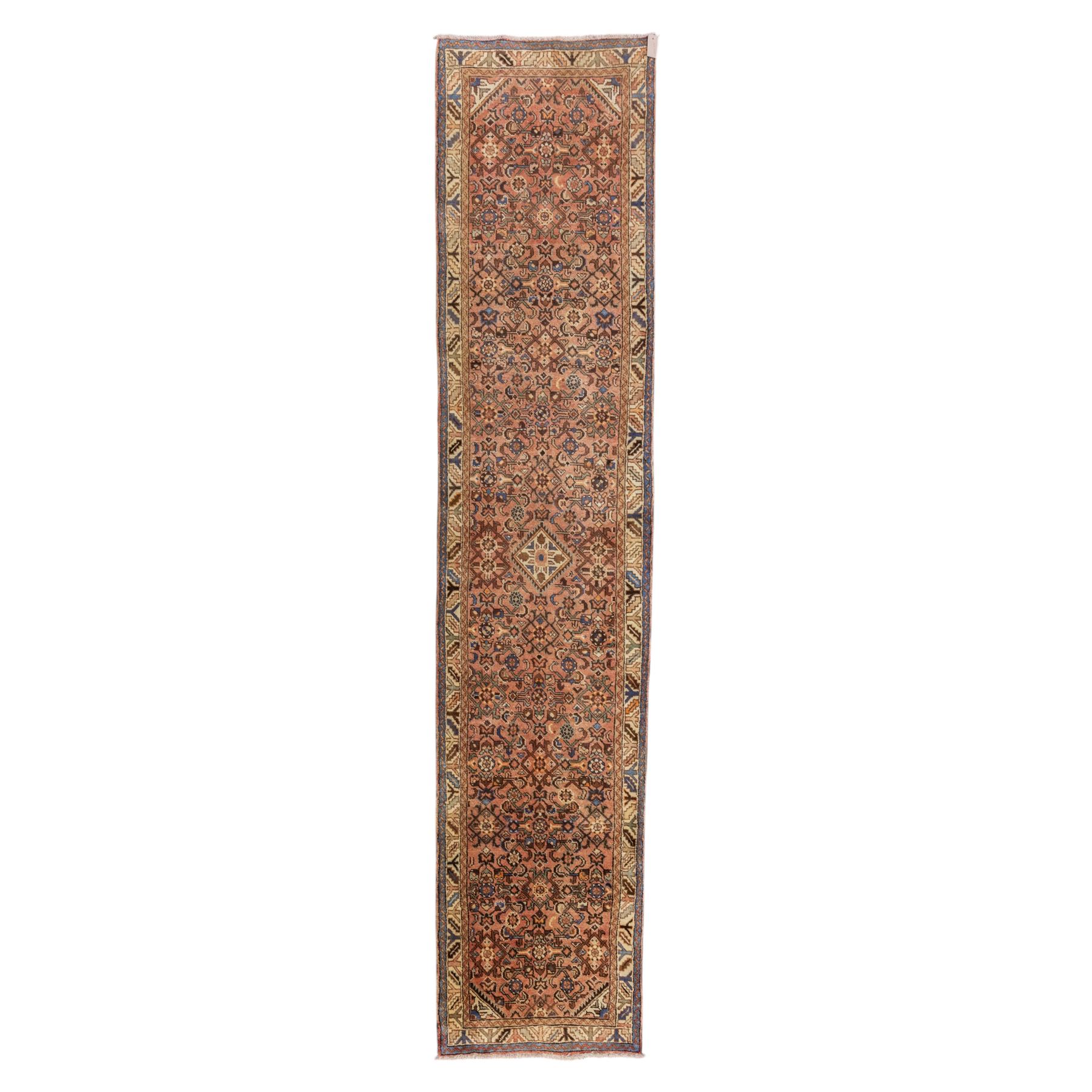 North West Persian Malayer hand-knotted runner, camel pink field decorated with an all-over lattice of Herati design, composed of rosettes and enclosed by angular leaves and stylized fish motifs, principal border of ivory ground decorated with stylized angular vine scroll and geometric palmettes, flanked by narrow guard stripes, with cotton fringe ends 