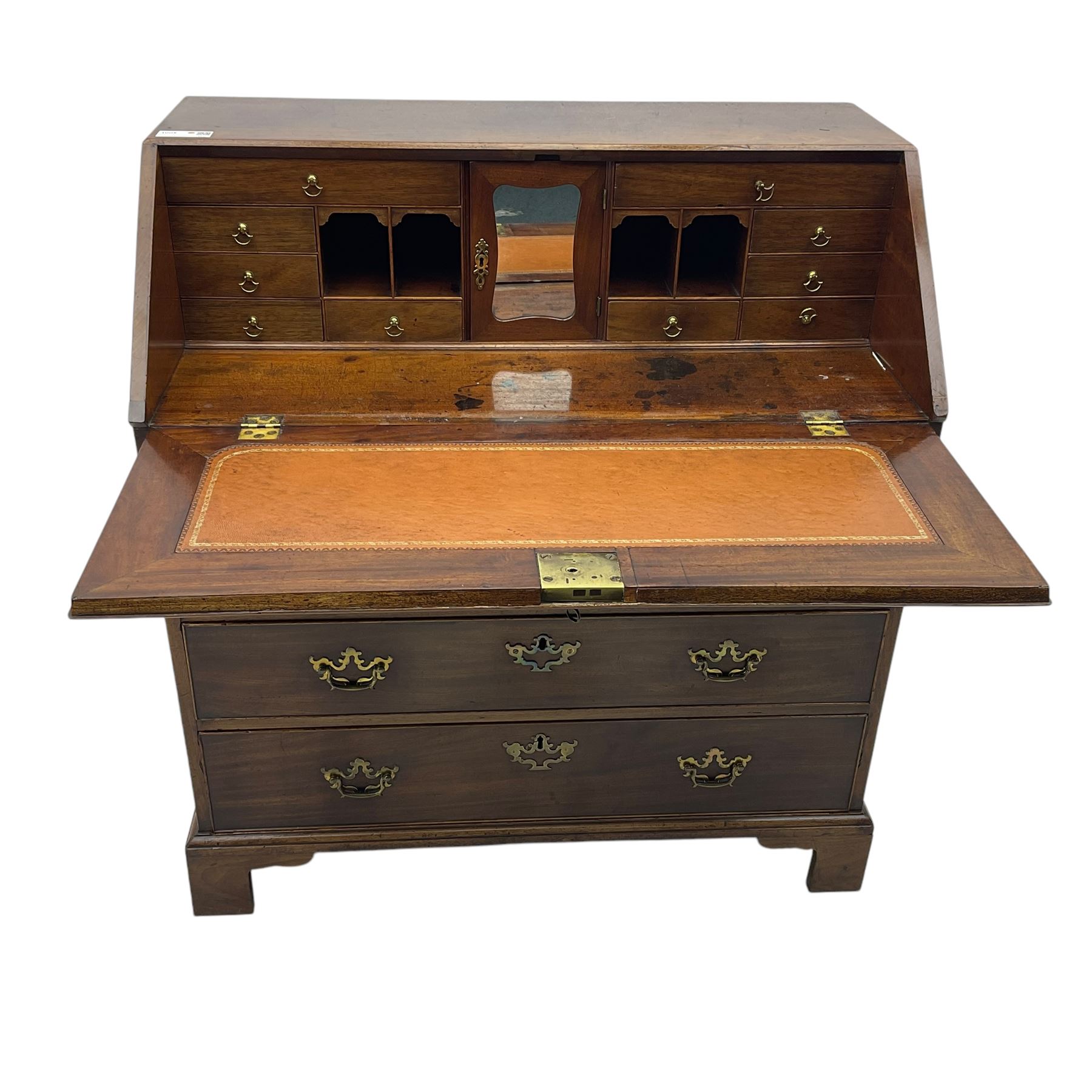 George III mahogany bureau, fall-front enclosing a fitted interior of drawers, pigeonholes and central mirrored cupboard, over four graduated cockbeaded drawers with brass batwing handles, raised on bracket feet