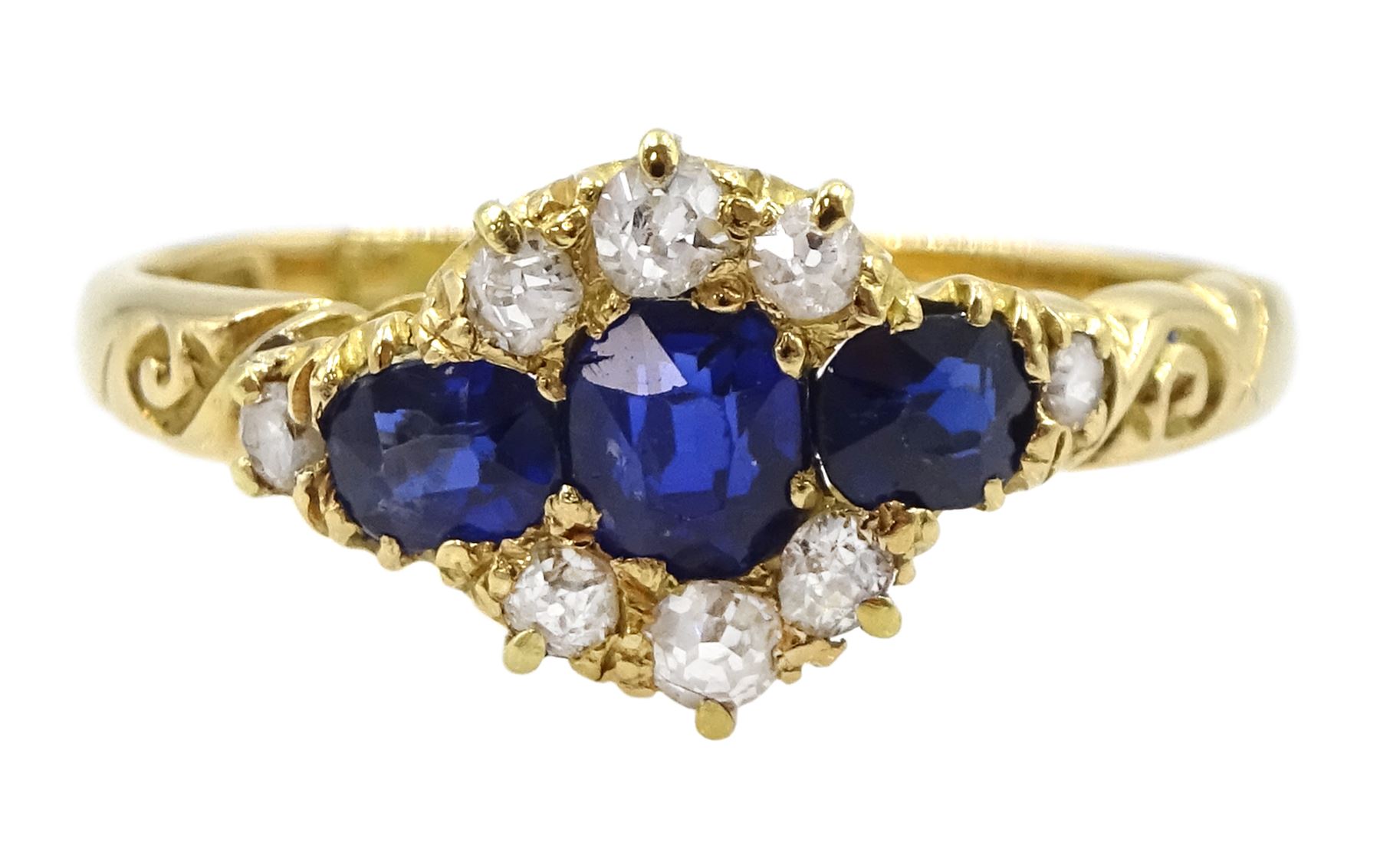 Victorian 18ct gold sapphire and diamond cluster ring, with engraved scroll design shoulders, Birmingham 1896