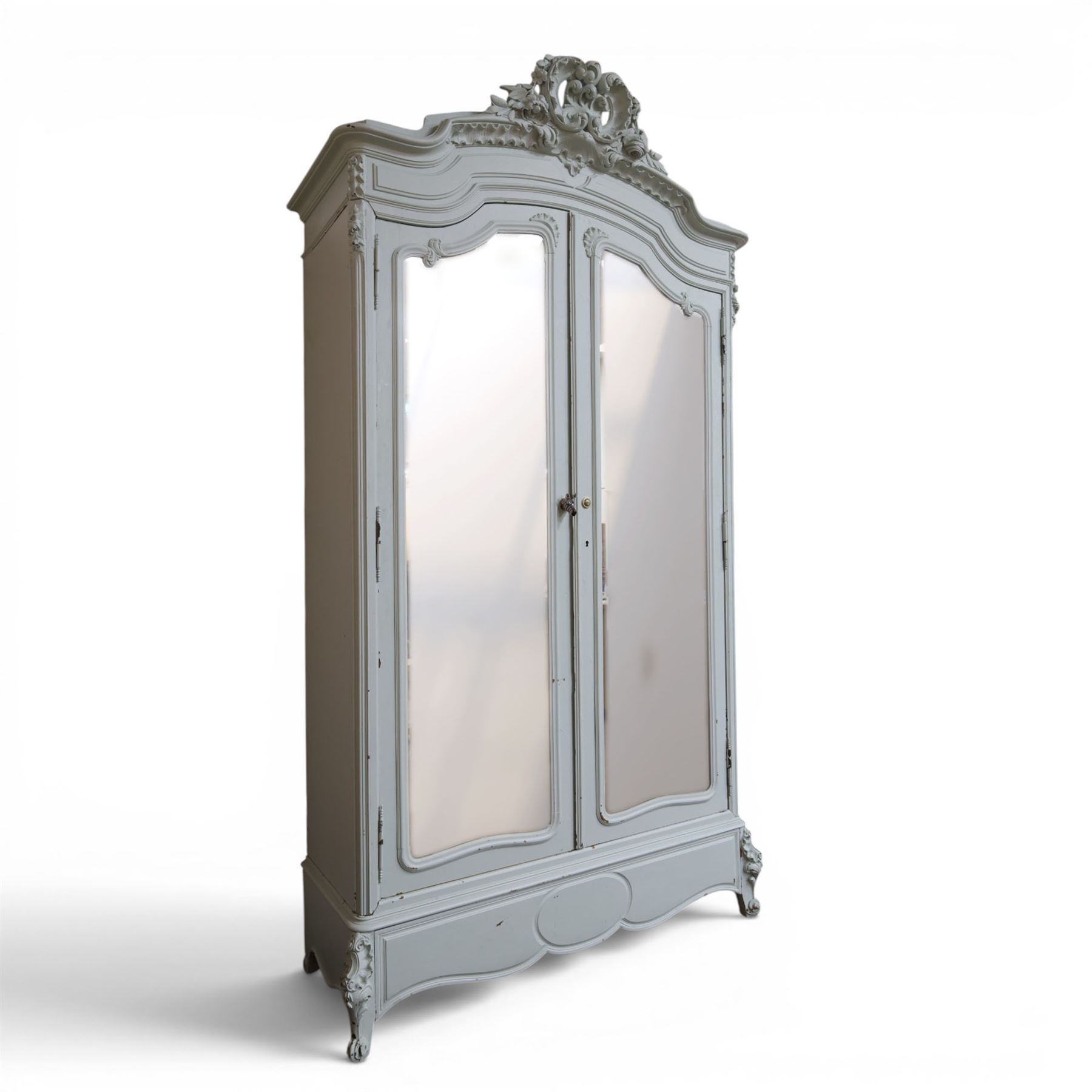 French Louis XV style pale blue painted armoire, with carved floral and foliate crest over a shaped moulded cornice, fitted with two bevelled mirror panel doors enclosing hanging space and drawer, above shaped apron, raised on carved cabriole supports
