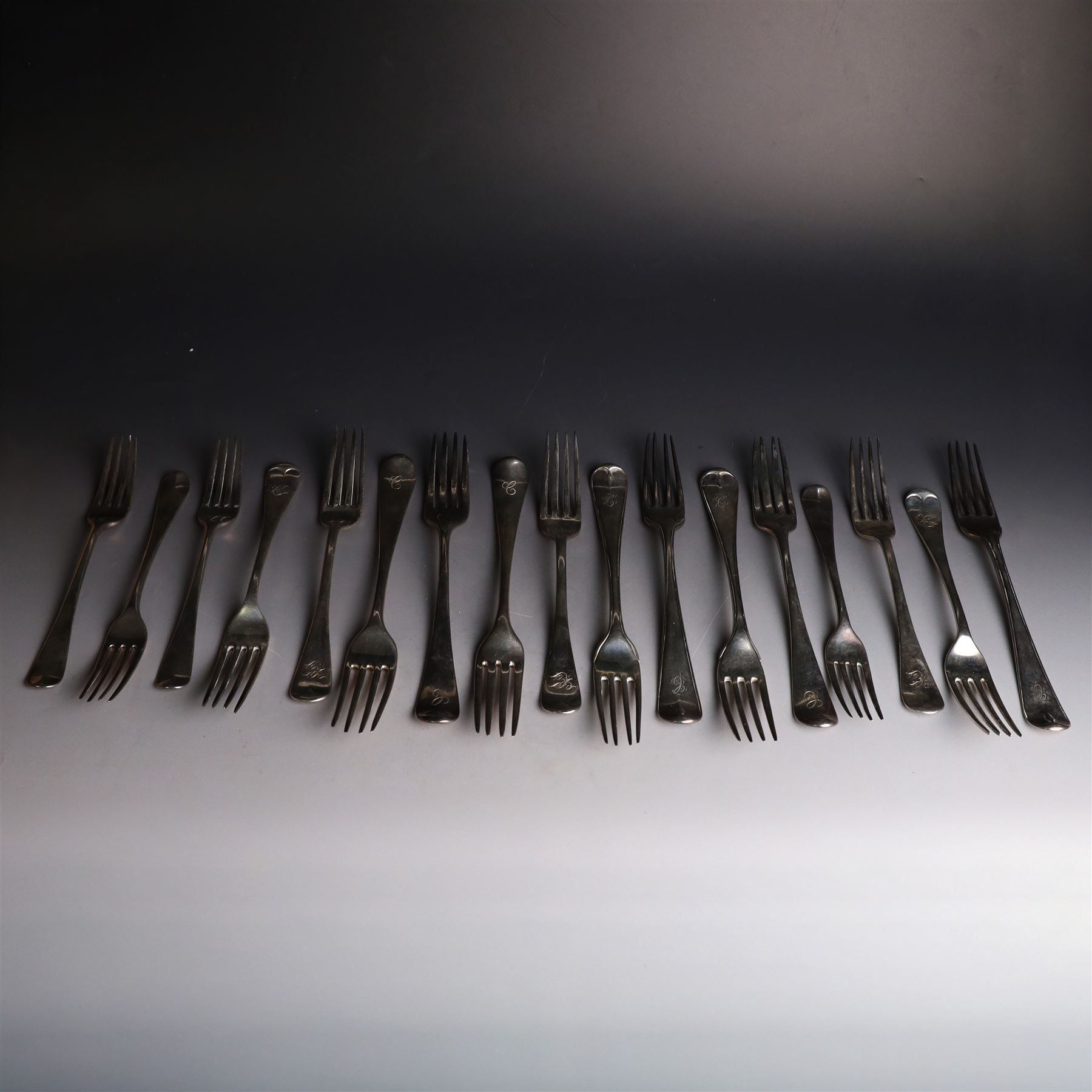 Seventeen Georgian and later silver Hanoverian pattern table and dessert forks, most with engraved initials to terminal and crests verso, including pair of table forks hallmarked William Sumner & Richard Crossley, London 1778