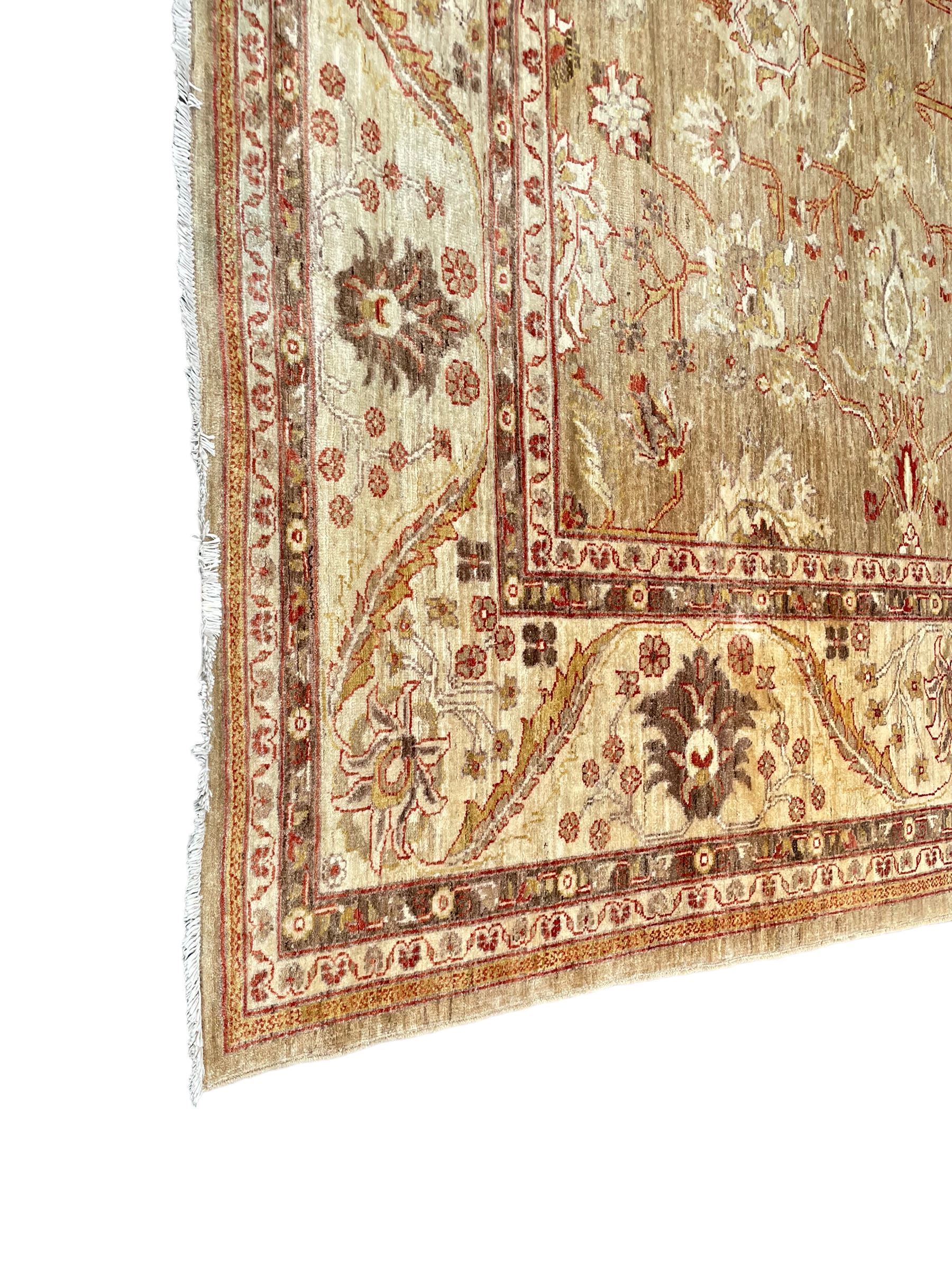 Pakistani ivory ground carpet, the field decorated with leaf branches, lotus flowers and roses, wide guarded border long leaves and stylised plant motifs