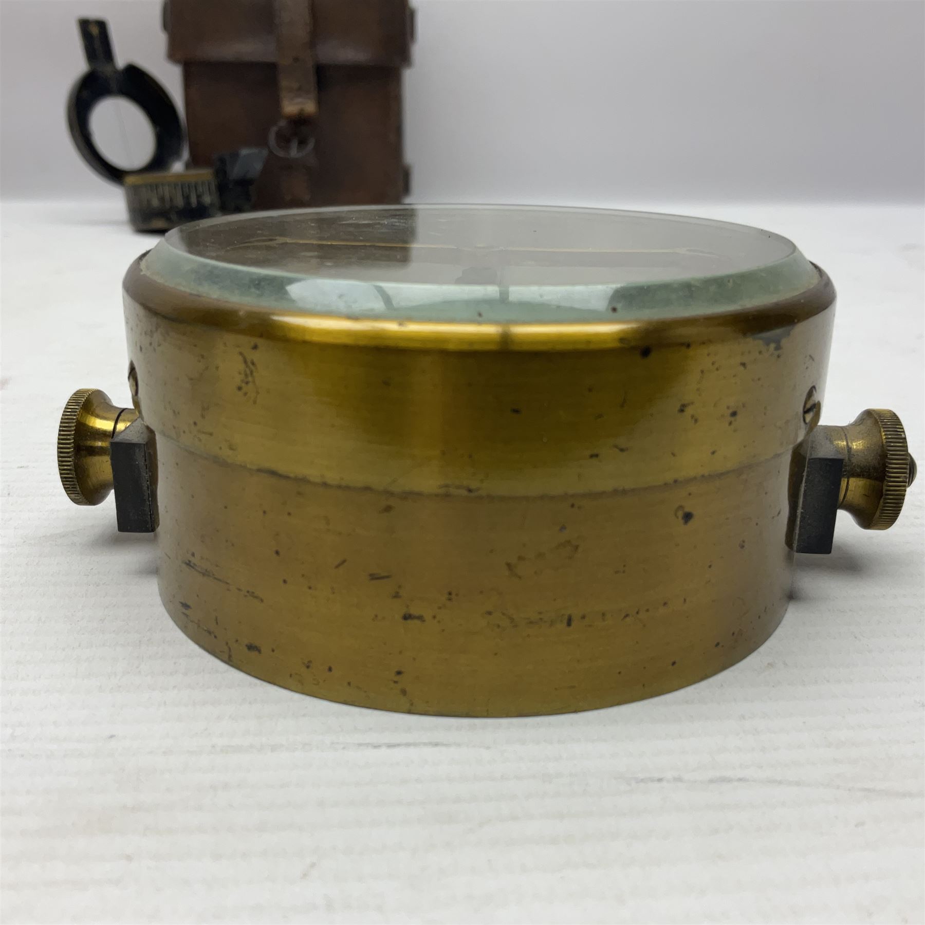 WWII British marching compass, the black lacquered brass case inscribed T.G.Co.Ltd. No.B100228 (broad arrow) 1941 Mk.III; and a ship's brass cased clinometer, the silvered dial marked R(arrow)L, D9cm; in leather carrying case (2)