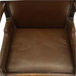 DD CL - Early 20th century oak open armchair, rectangular back with scrolled uprights, brown upholstered back and seat with brass stud edging, shaped open arms on turned supports, square legs united by stretchers