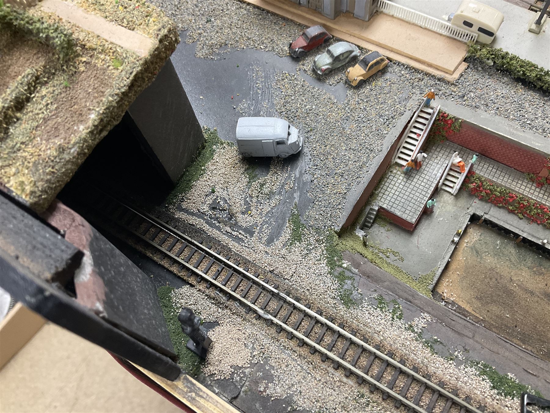 'Z' gauge continental scenic layout with folding legs, various loops of track and sidings with overhead cables, buildings including water tower, tunnels, roads with motor vehicles and figures, trees, haven with boats, backdrop diving wall hiding control units 150 x 50cm