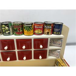 Late 1950s continental red and white painted wooden diorama of a grocery shop interior with fitted shelves and drawers and freestanding 'glazed' counter, fully stocked with miniature tin cans and packets of food L42cm H23cm D22cm