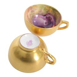 Two small 20th century Royal Worcester cabinet cups and saucers, together with another saucer, each painted with a still life of fruit upon a mossy ground, bearing various signatures: E Townsend, Ricketts, G H Cole, and H Ayrton, each with puce printed mark beneath, teacups approximately H3cm D5.5cm, coffee cup H4.5cm, saucers 9.5.cm