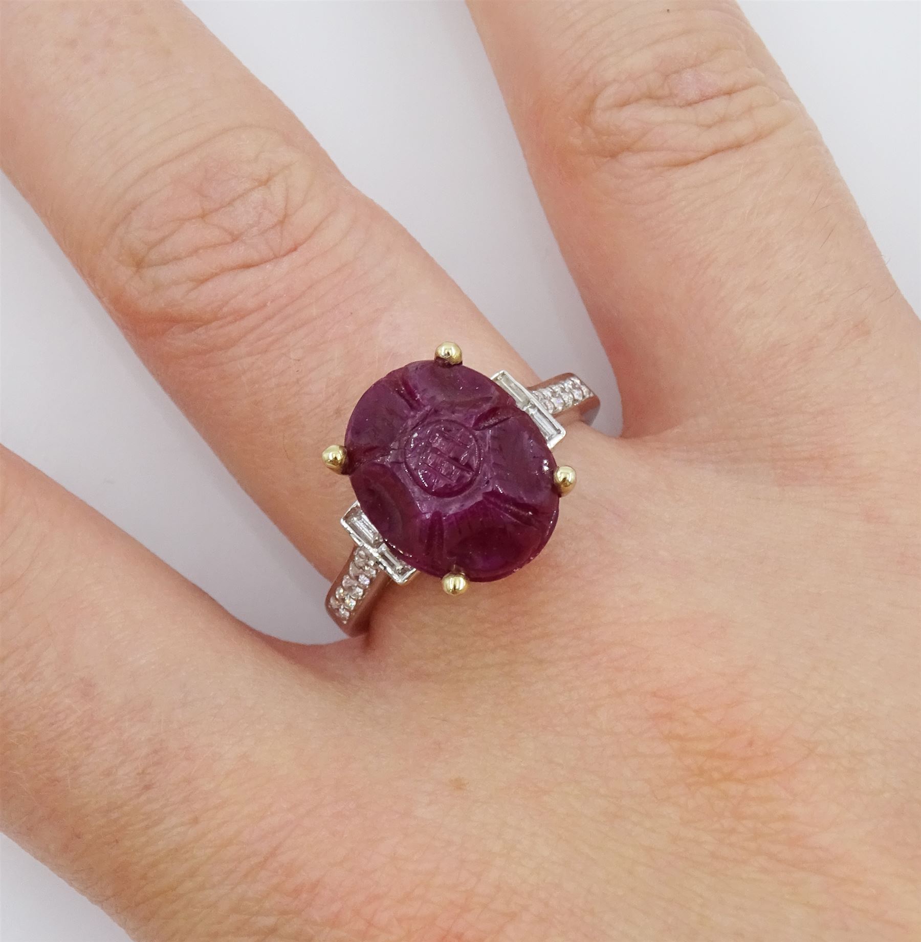 18ct white gold carved ruby ring, set with two baguette cut diamonds either side and diamond set shoulders, ruby approx 6.00 carat